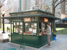 a man standing in front of a green kiosk