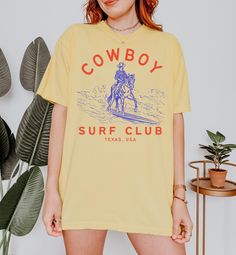 Cowboy Surf Club Coastal Cowgirl Summer Tshirt Beach Tee Western Graphic Tee Cute Country Shirt Oversized Short Sleeve Comfort Colors Tee All items are made to order. Items will ship within one week from my printing partner. Please allow time for production and shipping! If you have any issues or concerns please reach out via Etsy messages so I can help!  If you feel you received a defective/misprinted item please let me know within 30 days of receiving your order, I'm happy to work with you to find a resolution! For cancellation requests please reach out within an hour of placing your order! Comfort Colors introduces the "Comfort Colors 1717" garment-dyed t-shirt; a fully customizable tee made 100% with ring-spun cotton. The soft-washed, garment-dyed fabric brings extra coziness to your w Cowgirl Summer, Cute Country, Surf Club, Summer Tshirt, Western Graphic Tees, Beach Tee, Cute N Country, Coastal Cowgirl, Country Shirts