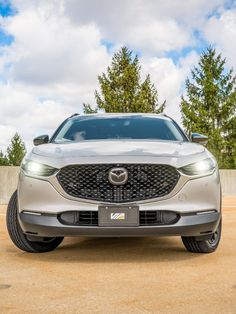 The front end of a platinum Mazda CX-30 with its lights on. Mazda Cx 30, Mazda, Wellness Design, Two Tone, Platinum, Bmw Car, Building