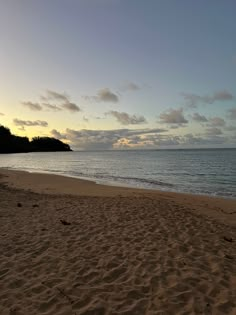 an empty beach with waves coming in from the ocean