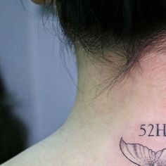 a woman with a tattoo on her neck has the number twenty five and is written in black ink