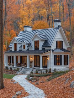 a white house surrounded by trees with leaves on the ground and in front is a path leading to it