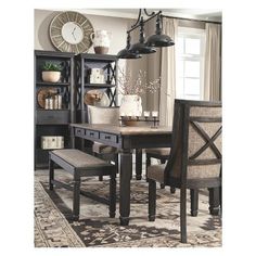 a dining room table with two chairs and a bench in front of it on an area rug