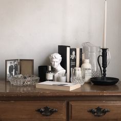 a wooden dresser topped with books and candles