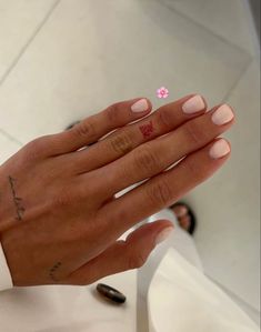 a woman's hand with a small pink flower on it