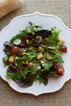 a white plate topped with salad and fruit