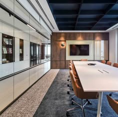 an empty conference room with chairs and a flat screen tv mounted on the wall above it