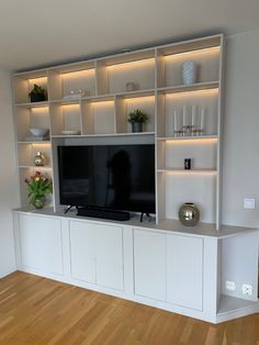 the entertainment center is built into the wall and has shelves with lights on each side