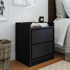 a night stand with two drawers and a lamp next to it on a wooden floor