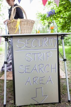 a sign that says security strip search area next to a picnic table with umbrellas