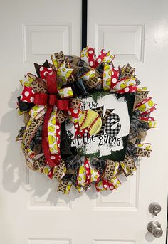 a baseball wreath on the front door with red and white bows, leopard print ribbon and polka dot bow