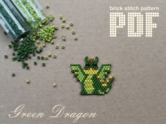 a green dragon brooch sitting on top of a table next to sprinkles