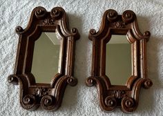 two wooden mirrors sitting on top of a white towel covered floor next to each other