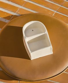 a small white sink sitting on top of a wooden table next to a tiled floor