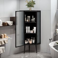 a black cabinet in the middle of a bathroom next to a bathtub and sink