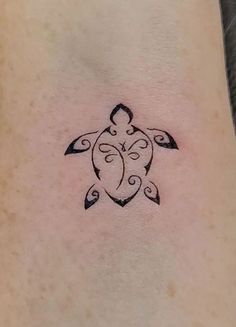 a small turtle tattoo on the back of a woman's left arm and neck