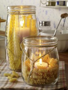 two jars filled with pasta and lit candles