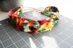 a flowered headband sitting on top of a cutting board