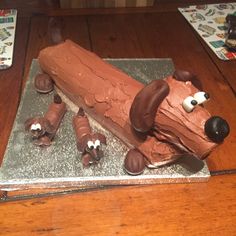 a cake made to look like a log with dogs on it and chocolate frosting