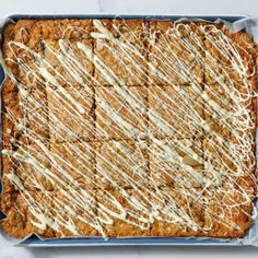 a blue dish filled with food covered in white icing and drizzled