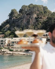 the man is holding two desserts in front of him