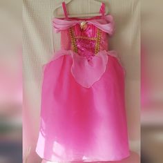 a pink princess dress hanging on a wall