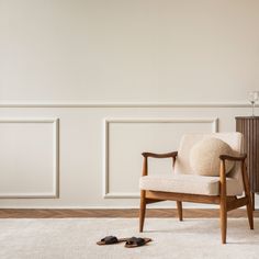 a pair of shoes sitting on top of a white rug next to a wooden chair