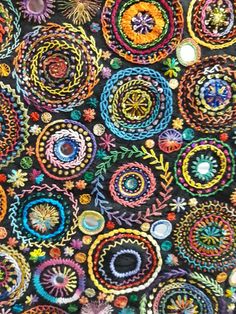 a close up view of a colorful wall hanging with many circles and flowers on it