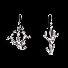 two pairs of silver earrings with cactus and cacti designs on them, against a black background