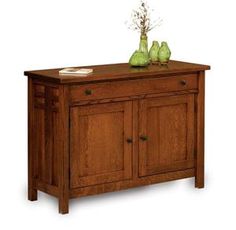 a wooden cabinet with two green vases on top