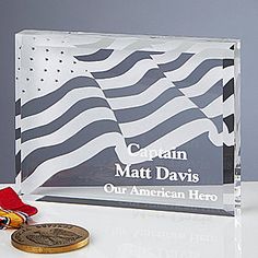 a glass award with an american flag on it and a medal in front of it