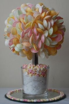 a cake sitting on top of a table next to a vase filled with candies