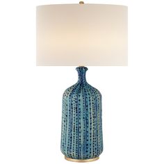 a blue ceramic lamp with a white shade on the base and a gold metal base