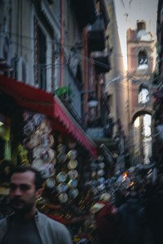 a man is walking down the street in front of some shops