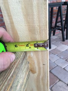 a person measuring the width of a piece of wood