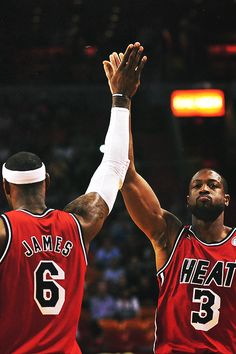 two basketball players are high fiving each other