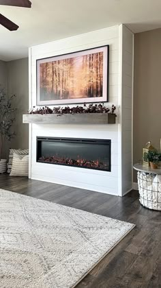 a living room with a white fireplace and large rugs on the hardwood flooring