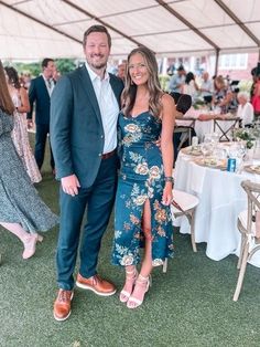 a man and woman standing next to each other under a tent