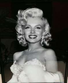 an old black and white photo of a woman in a wedding dress with big earrings