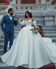 a man and woman in formal wear standing on steps next to each other holding hands