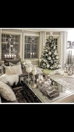 a living room filled with furniture and a christmas tree in the window sill next to it