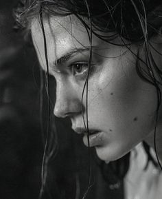 a black and white photo of a woman with wet hair