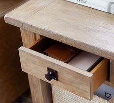 an open drawer on a wooden table with books