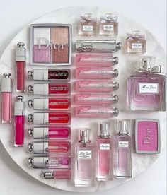 a white plate topped with lots of different types of perfumes on top of each other