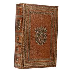 an old leather book with ornate designs on the front and back cover, isolated against a white background