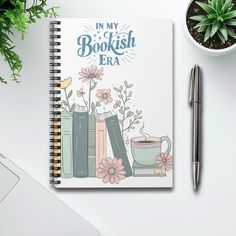 a notebook with the words in my bookish era on it next to a cup of coffee