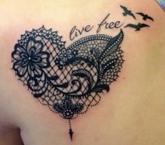 the back of a woman's shoulder with a black lace heart tattoo on it