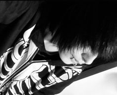 black and white photograph of a young boy with his head resting on the back of a car seat