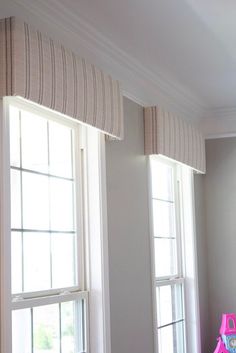 two windows with matching shades in a room