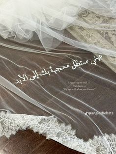 an image of wedding veils with arabic writing on the bottom, and white lace at the bottom